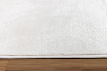 フローリングの床と、白い絨毯の写真