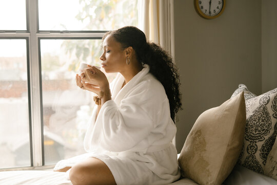 Woman drinking coffee at home in bed