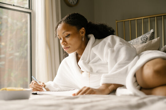 Black Woman Journaling At Home In Bed