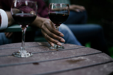 Black woman reaches for glass of red wine at party