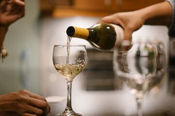 Friend pouring guest wine at house party