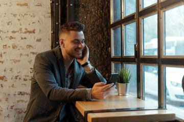 Happy young businessman with mobile phone