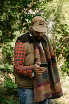 Black man holding smartphone in backyard in fall