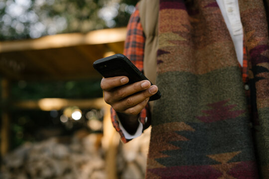 Man checking smartphone in backyard in fall