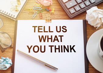 Tell Us What You Think text written on a notebook on office desk