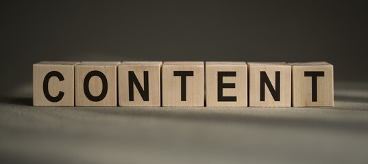 Content is a word written on wooden blocks on a gray background.