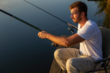 Handsome man fishing on the lake.