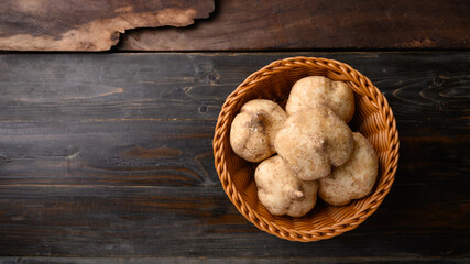 Fresh jicama or yam bean in a basket on wooden background, Jicama can be eaten raw or cooked, The taste are crisp, juicy, moist, and slightly sweet
