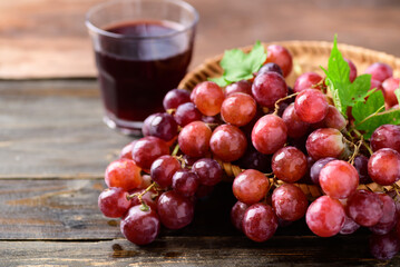 Fresh red grapes fruit and juice on wooden background