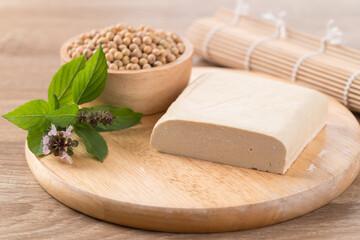 Fresh tofu and soybean seeds on wooden cutting board prepare for cooking, Asian vegan food
