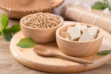 Fresh cube tofu and soybean seeds in a bowl on wooden cutting board prepare for cooking, Asian vegan food