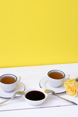 Two cups of tea and pecmez on a white wooden table and a yellow background. Breakfast. White flowers. grape juice, carob pecmez, Turkish sweetness. Yellow roses