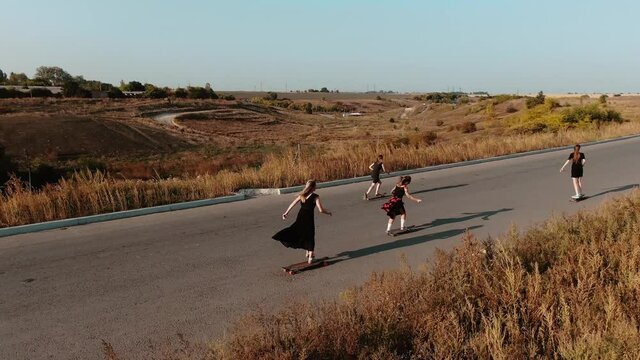 Trendy youth sport, longboarding women in dresses during sunset, 4k