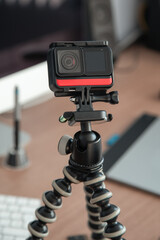 details of a small portable camera on a tripod with a microphone, background some elemnts of the office