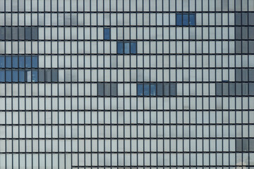 Background of reflected glass facade with rectangular windows grid frame structure and inner curtain of modern high rise office building. 