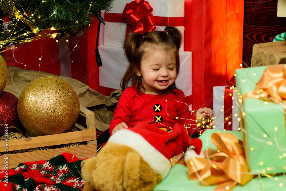 Wall mural amazed attractive baby girl in christmas costume.