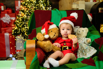Fototapeta na wymiar Christmas portrait of cute little baby in santa hat. New Year kids holidays.