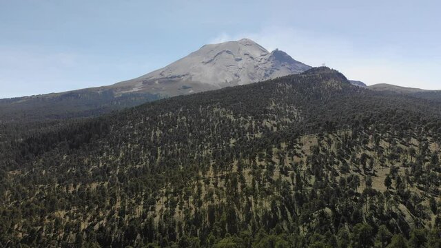 Vista a&eacute;rea sobre el valle del Paso de Cort&eacute;s, en Puebla M&eacute;xico, con el volc&aacute;n activo Popocat&eacute;petl y un cielo azul como fondo.