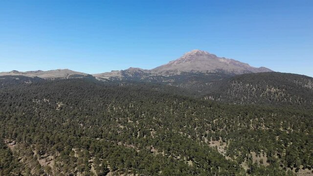 Espectacular vista a&eacute;rea sobre el Paso de Cort&eacute;s con el volc&aacute;n Iztacc&iacute;huatl, la mujer dormida, y un cielo azul como fondo.