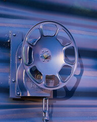 Closeup of a blue and purple metal spinning wheel on the caboose of a railroad train car