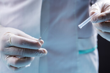 female doctor dressed white medical smock, surgical protective gloves. physician holding drug or vaccine syringe. studio shot. vaccination concept