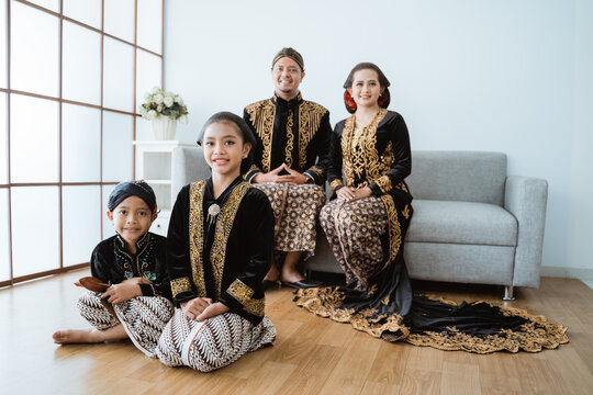 Portrait of a happy family wearing traditional Javanese clothes. concept of family photo Javanese traditional clothes in the living room