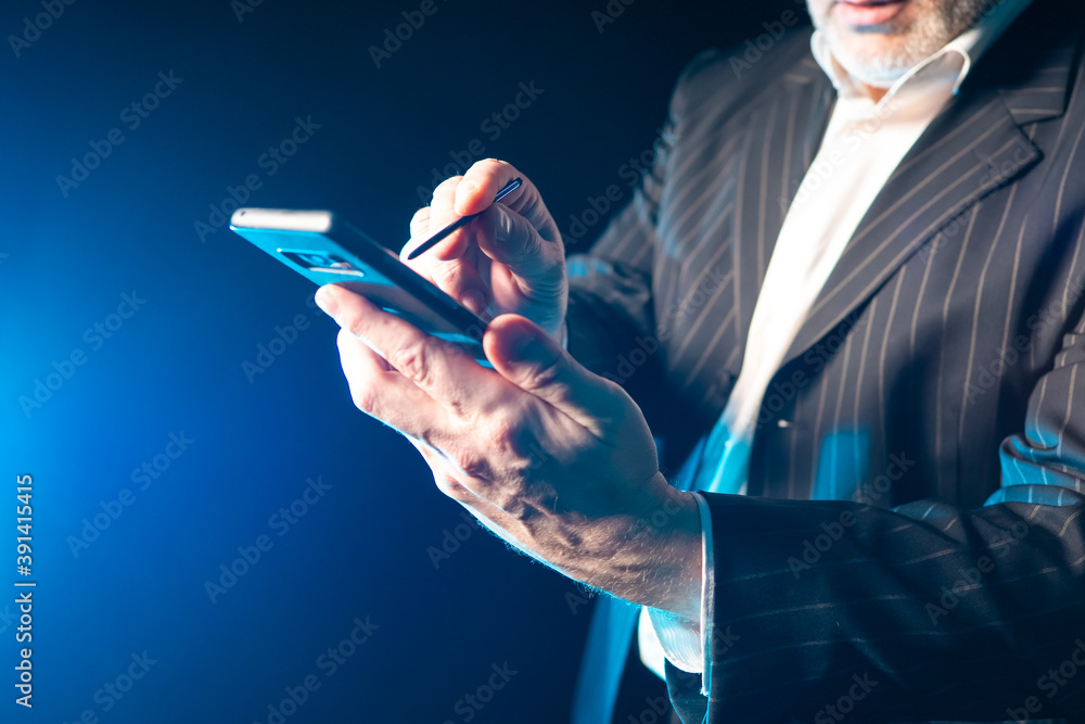 Poster a man with a phone in his hands. a man controls the phone with a stylus. a man works with a stylus. 