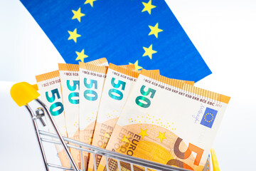 EU. Euro on the background of the flag of the European Union. Cash in a supermarket trolley. Concept - the financial market in Europe. Concept - shopping in the European Union. Taxing in EU