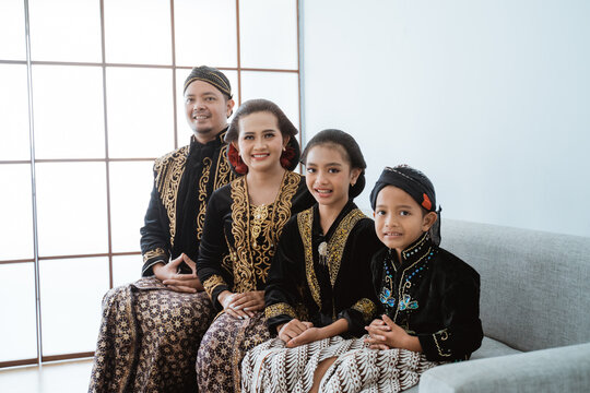 Portrait of a happy family wearing traditional Javanese clothes. concept of family photo Javanese traditional clothes in the living room