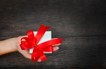 gift in hand on wooden background