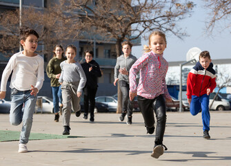 Obraz na płótnie Canvas Group of children running on city street and having fun