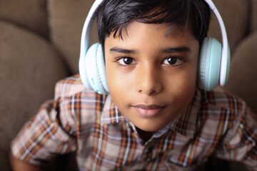 Indian young boy listen the speach with headphone	
