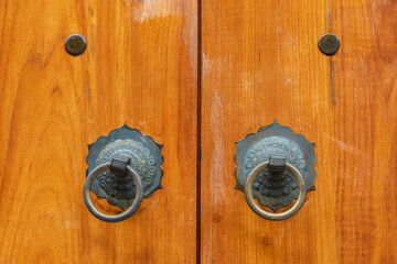 Chinese bronze handle on brown door. Oriental background