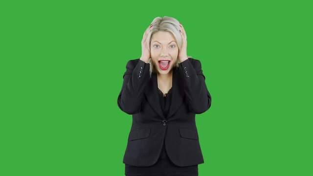 Attractive blonde woman in front of chroma key green screen is happy surprised and shocked. Her smiling face shows amazement as she can hardly contain her excitement.
