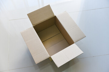 Open cardboard box on floor background High angle view of an empty cardboard box or Parcel box