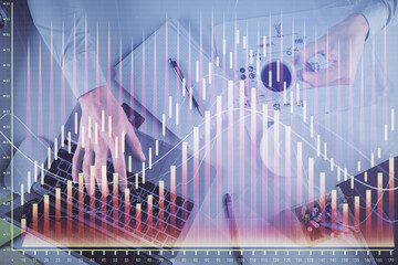 Multi exposure of man's hands typing over computer keyboard and forex graph hologram drawing. Top view. Financial markets concept.