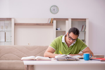 Young male student preparing for exams at home