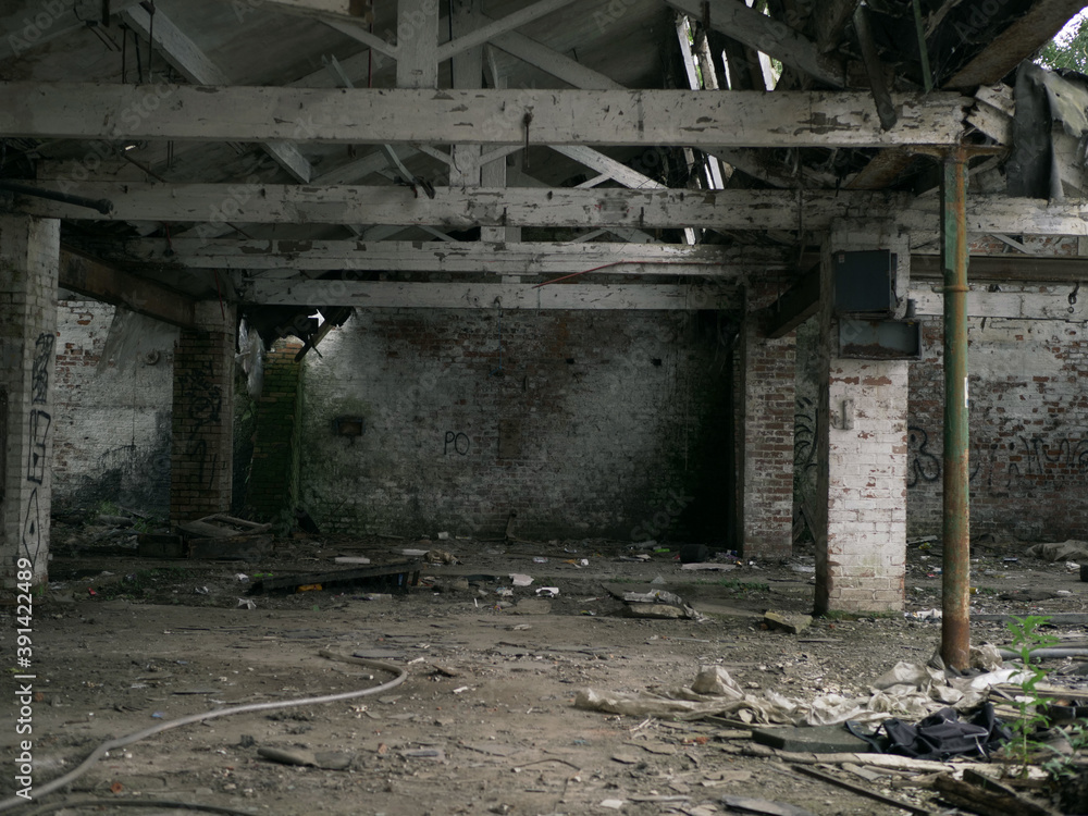 Poster inside of an old abandoned building with columns and garbage