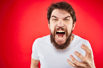 bearded man gesturing with hands white t-shirt emotions facial expression aggression red isolated background