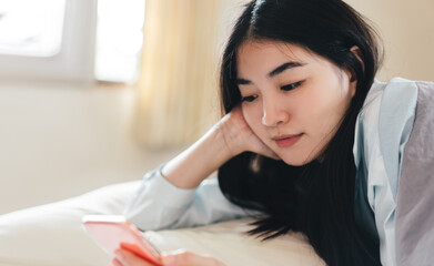 Young adult single woman using smartphone in the moring for social message app chat with friend