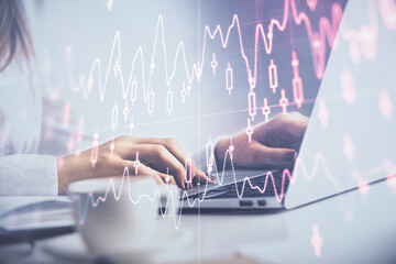 Naklejka premium Double exposure of woman hands working on computer and forex graph hologram drawing. Financial analysis concept.
