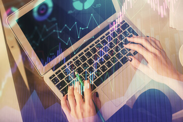 Double exposure of woman hands working on computer and forex chart hologram drawing. Top View. Financial analysis concept.