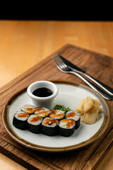 Sushi rolls as a lunch in european cafe, wooden table, side view