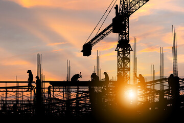 Silhouette of Engineer and worker checking project at building site background, construction site...
