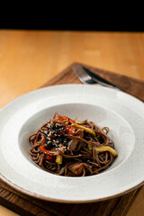 Buckwheat wok noodles with vegetables, close up, appetizing restaurant photo