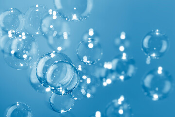 Beautiful shiny transparent soap bubbles float on dark blue background. Abstract, Natual fresh summer a blue texture.