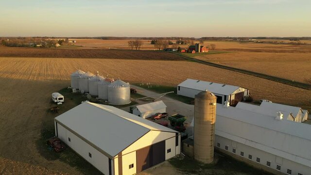 Aerial view of American countryside landscape in harvesting season. Harvested crop field,  farmhouse from above. Midwestern USA