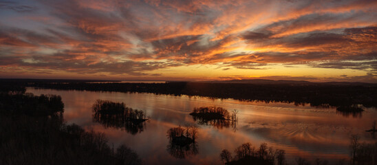 Fototapeta premium Panoramic aerial view of a dramatic sunset over the river in Laval, Quebec