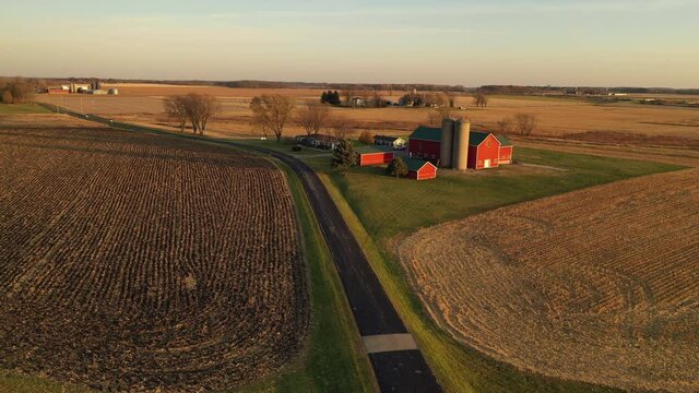 Aerial view of American countryside landscape in harvesting season. Harvested crop field,  farmhouse from above. Midwestern USA