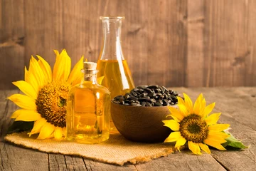 Gardinen Closeup photo of sunflower oil with seeds on wooden background. Bio and organic product concept. © xander21
